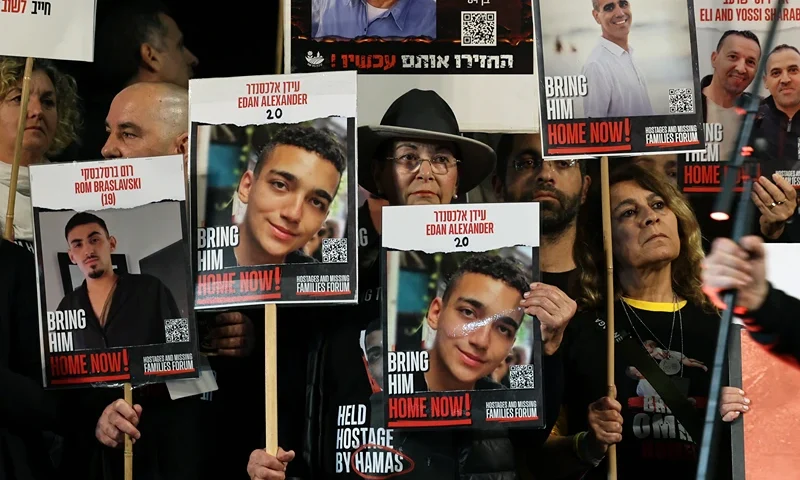 TOPSHOT - Relatives and supporters hold placards bearing portraits of Israeli hostages held in Gaza since the October 7 attacks by Hamas in southern Israel, during a rally calling for their release, in Tel Aviv on December 30, 2023. The placards (C) show Edan Alexander. (Photo by AHMAD GHARABLI / AFP) (Photo by AHMAD GHARABLI/AFP via Getty Images)