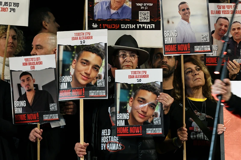 TOPSHOT - Relatives and supporters hold placards bearing portraits of Israeli hostages held in Gaza since the October 7 attacks by Hamas in southern Israel, during a rally calling for their release, in Tel Aviv on December 30, 2023. The placards (C) show Edan Alexander. (Photo by AHMAD GHARABLI / AFP) (Photo by AHMAD GHARABLI/AFP via Getty Images)