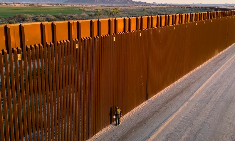 YUMA, ARIZONA - MARCH 09: In an aerial view, a U.S. Border Patrol agent searches for immigrant footprints while looking through the U.S.-Mexico border fence on March 9, 2024 in Yuma, Arizona. Although new arrivals have dipped since the beginning of the year, officials expect the numbers to grow, as migrants cross the desert before the dangerously hot summer season. The border between the two nations stretches nearly 2,000 miles, from the Gulf of Mexico to the Pacific Ocean and is marked by fences, deserts, mountains and a river that runs through most of it. The politics and controversies surrounding border and immigration issues have become dominant themes in the U.S. presidential election campaign. (Photo by John Moore/Getty Images)