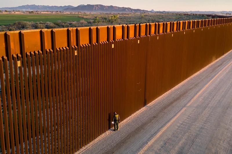 YUMA, ARIZONA - MARCH 09: In an aerial view, a U.S. Border Patrol agent searches for immigrant footprints while looking through the U.S.-Mexico border fence on March 9, 2024 in Yuma, Arizona. Although new arrivals have dipped since the beginning of the year, officials expect the numbers to grow, as migrants cross the desert before the dangerously hot summer season. The border between the two nations stretches nearly 2,000 miles, from the Gulf of Mexico to the Pacific Ocean and is marked by fences, deserts, mountains and a river that runs through most of it. The politics and controversies surrounding border and immigration issues have become dominant themes in the U.S. presidential election campaign. (Photo by John Moore/Getty Images)