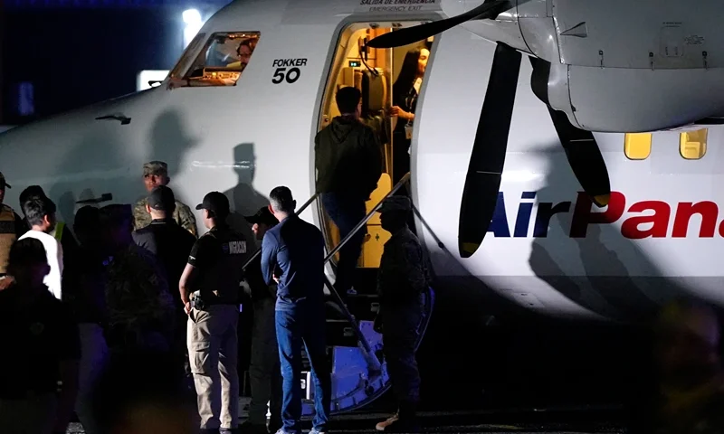 An Ecuadorian migrant, with his hands handcuffed, climbs a plane during a deportation flight of migrants to Ecuador, in the framework of the memorandum of cooperation signed between Panama and the United States, at the Albrook "Marcos A. Gelabert" International Airport in Panama City on September 20, 2024. (Photo by ARNULFO FRANCO / AFP) (Photo by ARNULFO FRANCO/AFP via Getty Images)