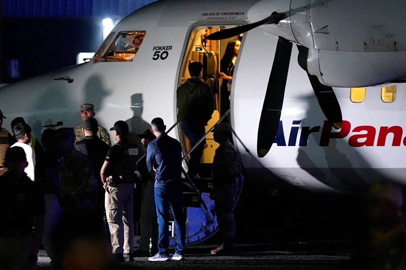 An Ecuadorian migrant, with his hands handcuffed, climbs a plane during a deportation flight of migrants to Ecuador, in the framework of the memorandum of cooperation signed between Panama and the United States, at the Albrook "Marcos A. Gelabert" International Airport in Panama City on September 20, 2024. (Photo by ARNULFO FRANCO / AFP) (Photo by ARNULFO FRANCO/AFP via Getty Images)