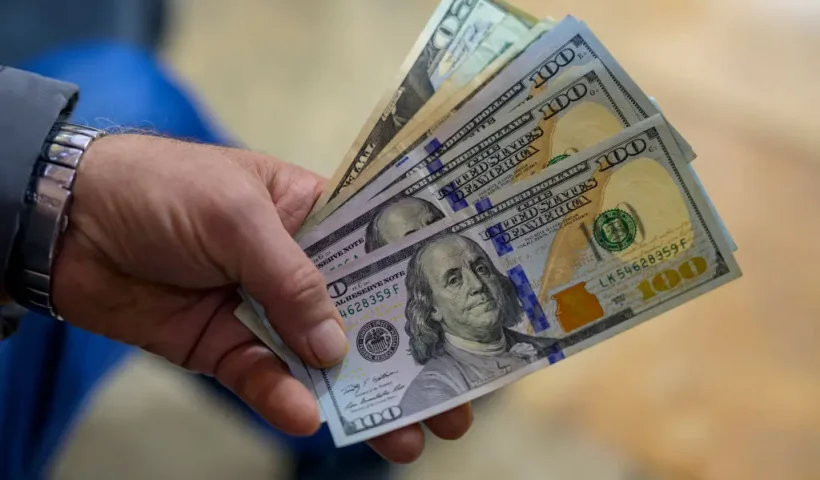 A teller shows US dollar bills at an exchange office at the Grand Bazaar in Istanbul on November 28, 2024. In recent weeks, the Turkish market has been increasingly unsettled by growing concerns over the circulation of counterfeit $50 and $100 bills. (Photo by Yasin AKGUL / AFP) (Photo by YASIN AKGUL/AFP via Getty Images)