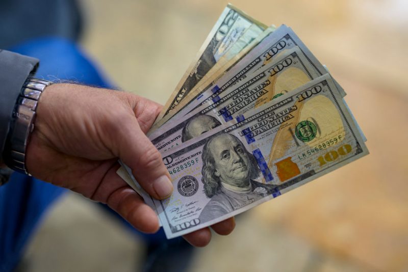 A teller shows US dollar bills at an exchange office at the Grand Bazaar in Istanbul on November 28, 2024. (Photo by Yasin AKGUL / AFP) (Photo by YASIN AKGUL/AFP via Getty Images)
