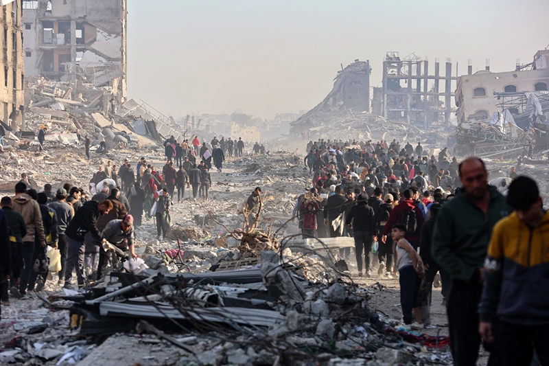 TOPSHOT - Scores of displaced Palestinians walk along a road in the Saftawi area of Jabalia, as they leave areas near Gaza City where they had taken refuge, toward the further northern part of the Gaza Strip, on January 19, 2025, shortly after a ceasefire deal in the war between Israel and the Palestinian militant group Hamas was expected to be implemented. The long-awaited ceasefire in the Israel-Hamas war was delayed January 19 after Prime Minister Benjamin Netanyahu said at the last minute that it would not take effect until the Palestinian militant group provided a list of the hostages to be released. (Photo by Omar AL-QATTAA / AFP) (Photo by OMAR AL-QATTAA/AFP via Getty Images)