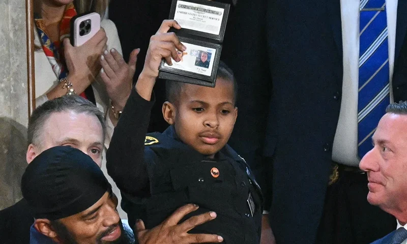 TOPSHOT - 13-year-old cancer survivor Devarjaye "DJ" Daniel is lifted up by his father Theodis Daniel after given credentials from US Secret Service Director Sean Curran after US President Donald Trump made him an honorary member of the US Secret Service during his address to a joint session of Congress at the US Capitol in Washington, DC, on March 4, 2025. (Photo by SAUL LOEB / AFP) (Photo by SAUL LOEB/AFP via Getty Images)