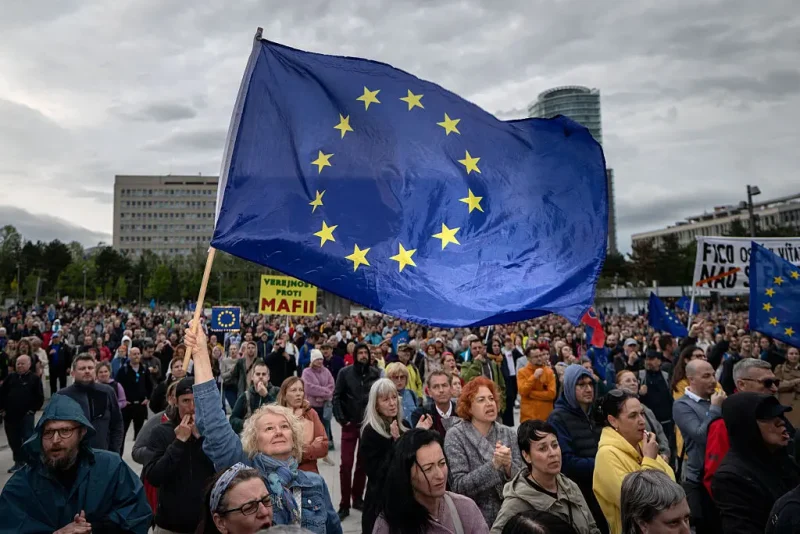 A woman holds an EU flag as people take part in an anti-government protest organized by political activists of the Peace in Ukraine organization under the slogan "No to the Russian Law", against a planned law intended to complicate the work of non-governmental organizations on April 24, 2025, in Bratislava, Slovakia. (Photo by TOMAS BENEDIKOVIC / AFP) (Photo by TOMAS BENEDIKOVIC/AFP via Getty Images)