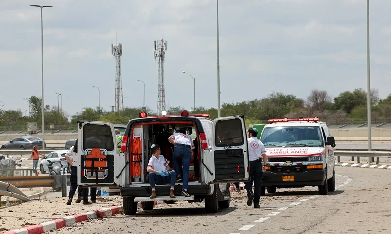 Israeli medical emergency services stand by on a mud-splattered road outside Israel's Ben Gurion airport after a missile struck near the facility on May 4, 2025. A missile launched from Yemen struck near Israel's main international airport on May 4, Israeli authorities said, an attack that briefly halted air traffic and triggered threats of retaliation. (Photo by Jack GUEZ / AFP) (Photo by JACK GUEZ/AFP via Getty Images)