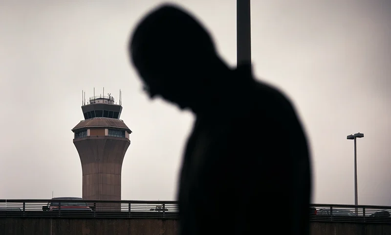 NEWARK, NEW JERSEY - MAY 6: A man stands outside Terminal C with the airport control tower in the background at Newark Liberty International Airport, on May 6, 2025 in Newark, New Jersey. Passengers traveling to, from, or through Newark Liberty International Airport (EWR) have experienced several days of delays and cancellations caused by air traffic control staffing shortages and equipment malfunctions.(Photo by Andres Kudacki/Getty Images)