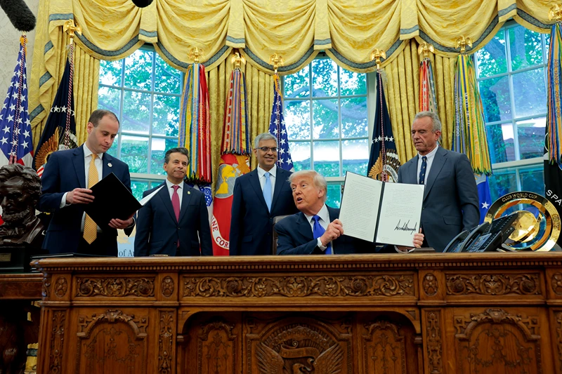 WASHINGTON, DC - MAY 05: U.S. President Donald Trump, accompanied by White House staff secretary Will Scharf (L), Food and Drug Administration Commissioner Marty Makary (2nd-L), National Institutes of Health Director Jayanta Bhattacharya (3rd-L), and Health and Human Services Secretary Robert F. Kennedy Jr. holds up a newly-signed executive order in the Oval Office at the White House on May 05, 2025 in Washington, DC. Trump signed new proclamations and executive orders, including one that ended federal funding for so-called "gain-of-function" studies. (Photo by Anna Moneymaker/Getty Images)