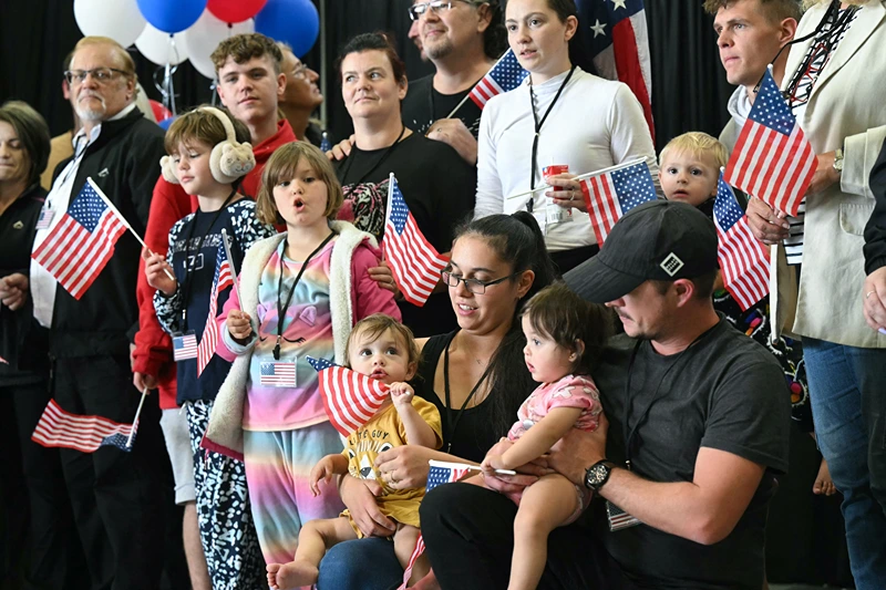The first group of Afrikaners from South Africa to arrive for resettlement listen to remarks from US Deputy Secretary of State Christopher Landau and US Deputy Secretary of Homeland Security Troy Edgar (both out of frame), after they arrived at Washington Dulles International Airport in Dulles, Virginia, on May 12, 2025. President Donald Trump on Monday defended the decision to resettle a group of white Afrikaners in the United States as refugees, saying they were fleeing a "terrible situation" in South Africa. Trump's remarks to reporters at the White House came just hours before an initial group of around 50 Afrikaners was set to arrive at an airport outside Washington. (Photo by SAUL LOEB / AFP) (Photo by SAUL LOEB/AFP via Getty Images)