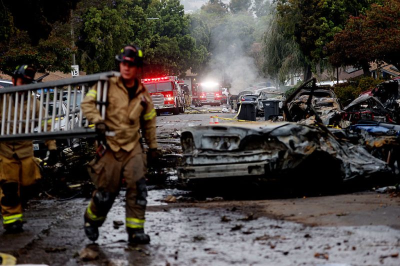Firefighters work the site where a small plane crashed into a San Diego, California, residential street on May 22, 2025. The Federal Aviation Authority said a Cessna 550 crashed at around 3:45 am local time. The neighborhood is close to the Montgomery-Gibbs Executive Airport. The crash left a "gigantic debris field" and damaged some 15 homes and parked cars, ABC News quoted the San Diego assistant fire chief as saying. (Photo by Sandy Huffaker / AFP) (Photo by SANDY HUFFAKER/AFP via Getty Images)