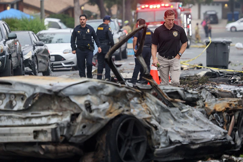 Investigators look through the site where a small plane crashed into a San Diego, California, residential street on May 22, 2025. The Federal Aviation Authority said a Cessna 550 crashed at around 3:45 am local time. The neighborhood is close to the Montgomery-Gibbs Executive Airport. The crash left a "gigantic debris field" and damaged some 15 homes and parked cars, ABC News quoted the San Diego assistant fire chief as saying. (Photo by Sandy Huffaker / AFP) (Photo by SANDY HUFFAKER/AFP via Getty Images)