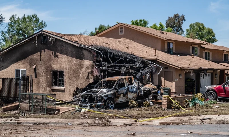 A house is damaged after a small plane crashed into a neighborhood, setting homes and vehicles on fire on May 22, 2025 in San Diego, California. At least two people have died after a Cessna 550 aircraft crashed into a residential street in Murphy Canyon, causing evacuations after buildings were damaged. (Photo by Ariana Drehsler/Getty Images)
