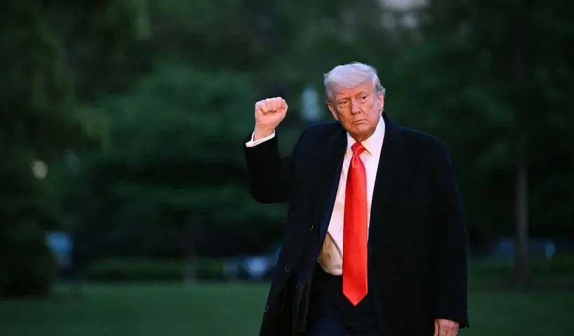 US President Donald Trump pumps his fist upon arrival at the South Lawn of the White House in Washington, DC, on May 22, 2025. Trump attended a private dinner at Trump National Golf Club. (Photo by Mandel NGAN / AFP) (Photo by MANDEL NGAN/AFP via Getty Images)