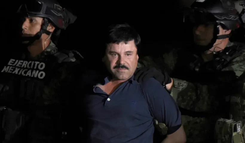 TOPSHOT - Drug kingpin Joaquin "El Chapo" Guzman is escorted into a helicopter at Mexico City's airport on January 8, 2016 following his recapture during an intense military operation in Los Mochis, in Sinaloa State. Mexican marines recaptured fugitive drug kingpin Joaquin "El Chapo" Guzman on Friday in the northwest of the country, six months after his spectacular prison break embarrassed authorities. AFP PHOTO / ALFREDO ESTRELLA (Photo by ALFREDO ESTRELLA / AFP) (Photo by ALFREDO ESTRELLA/AFP via Getty Images)
