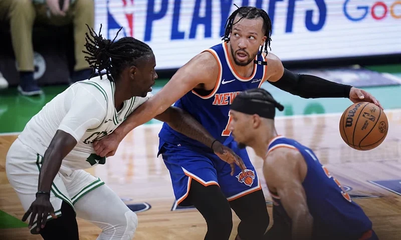 New York Knicks guard Jalen Brunson (11) moves the ball against Boston Celtics guard Jrue Holiday (4) in overtime during game one of the second round for the 2025 NBA Playoffs at TD Garden. Mandatory Credit: David Butler II-Imagn Image