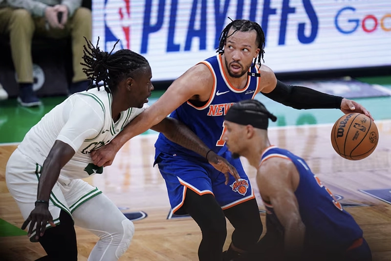 New York Knicks guard Jalen Brunson (11) moves the ball against Boston Celtics guard Jrue Holiday (4) in overtime during game one of the second round for the 2025 NBA Playoffs at TD Garden. Mandatory Credit: David Butler II-Imagn Image