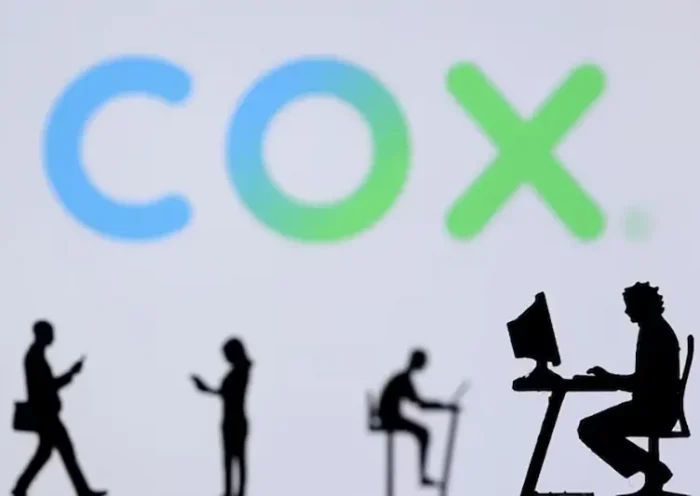 Small toy figures with laptops and smartphones are seen in front of displayed COX Internet logo, in this illustration taken December 5, 2021. REUTERS/Dado Ruvic/Illustration/File Photo