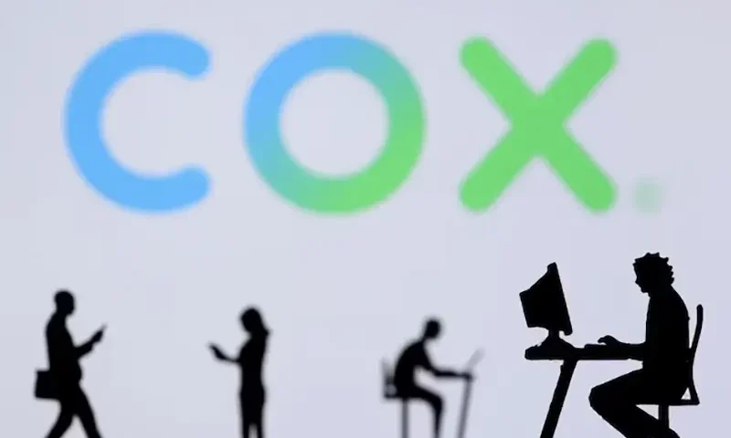 Small toy figures with laptops and smartphones are seen in front of displayed COX Internet logo, in this illustration taken December 5, 2021. REUTERS/Dado Ruvic/Illustration/File Photo