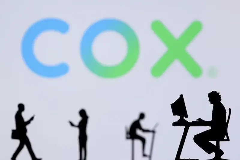 Small toy figures with laptops and smartphones are seen in front of displayed COX Internet logo, in this illustration taken December 5, 2021. REUTERS/Dado Ruvic/Illustration/File Photo