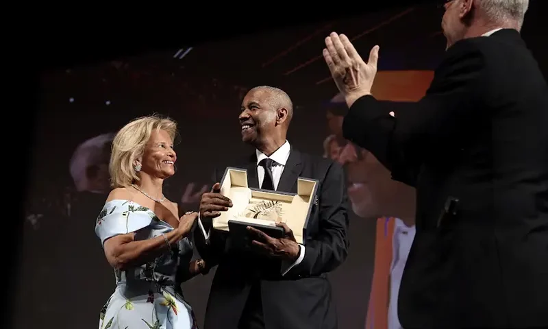 Denzel Washington receives the Honorary Palme d'Or next to Cannes Film Festival General Delegate Thierry Fremaux and German president of the cannes film festival Iris Knobloch ahead of the screening of the film "Highest 2 Lowest" at the 78th edition of the Cannes Film Festival in Cannes, southern France, on May 19, 2025. VALERY HACHE/Pool via REUTERS