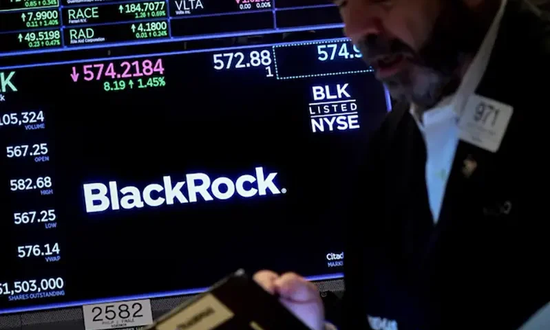 A trader works as a screen displays the trading information for BlackRock on the floor of the New York Stock Exchange (NYSE) in New York City, U.S., October 14, 2022. REUTERS/Brendan McDermid/File Photo