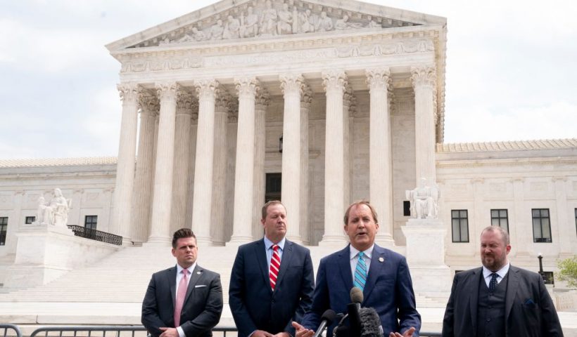 Texas Attorney General Ken Paxton (2R) and Missouri Attorney General Eric Schmitt (2L) speak to reporters in front of the US Supreme Court in Washington, DC, on April 26, 2022. - The Supreme Court will hear oral arguments Tuesday in the Biden v. Texas case, which will determine if the Biden administration must continue to enforce a Trump-era program known as the remain in Mexico policy. The court is considering whether President Joe Biden can end a controversial Trump-era border policy that denies asylum-seekers entry to the US while their case is reviewed. (Photo by Stefani Reynolds / AFP) (Photo by STEFANI REYNOLDS/AFP via Getty Images)