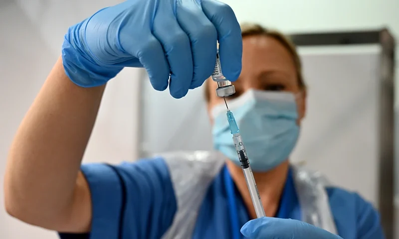 GLASGOW, SCOTLAND - DECEMBER 08: Grace Thomson receives the coronavirus vaccine from Paula McMahon at the Louisa Jordan Hospital as the roll out begins on December 8, 2020 in Glasgow, Scotland. A batch of 65,000 doses of the Pfizer BioNTech vaccine arrived in the country at the weekend, it will be offered to all those over the age of eighteen a total of about 4.4 million people in Scotland. (Photo by Jeff J Mitchell - Pool /Getty Images)