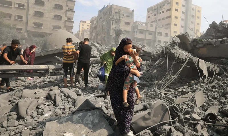 TOPSHOT - Palestinians evacuate the area following an Israeli airstrike on the Sousi mosque in Gaza City on October 9, 2023. Israel continued to battle Hamas fighters on October 9 and massed tens of thousands of troops and heavy armour around the Gaza Strip after vowing a massive blow over the Palestinian militants' surprise attack. (Photo by Mahmud HAMS / AFP) (Photo by MAHMUD HAMS/AFP via Getty Images)