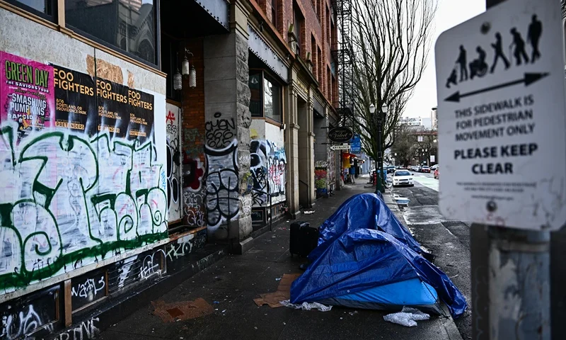 People camp in tents near the former location of Mother's Bistro on the corner of Southwest Second Avenue Southwest Harvey Milk Street, since boarded up and covered with graffiti after the business moved to a larger location before the pandemic, in Portland, Oregon on January 24, 2024. In the midst of a presidential election year, Portland's decline is brandished by the conservative press depicting a city ravaged by its progressive ideals, in a state controlled by the left for over 40 years. (Photo by Patrick T. Fallon / AFP) (Photo by PATRICK T. FALLON/AFP via Getty Images)