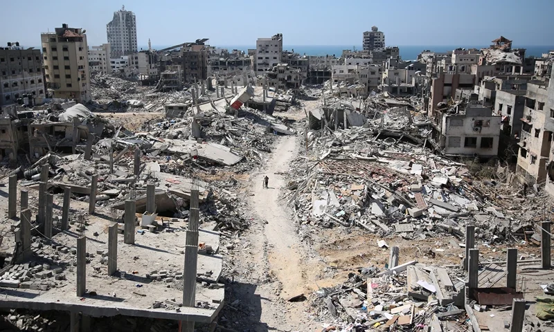 TOPSHOT - A man pushes a bycicle along as he walks amid building rubble in the devastated area around Gaza's Al-Shifa hospital on April 3, 2024, amid the ongoing conflict between Israel and the Palestinian Hamas militant group. (Photo by AFP) (Photo by -/AFP via Getty Images)