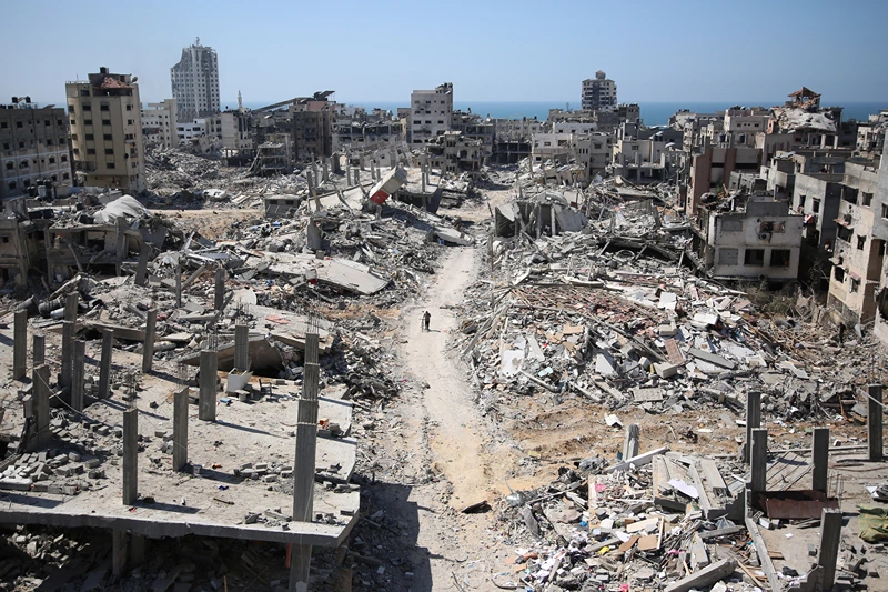 TOPSHOT - A man pushes a bycicle along as he walks amid building rubble in the devastated area around Gaza's Al-Shifa hospital on April 3, 2024, amid the ongoing conflict between Israel and the Palestinian Hamas militant group. (Photo by AFP) (Photo by -/AFP via Getty Images)