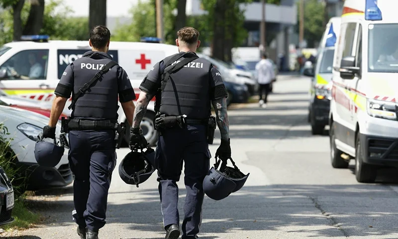 Two policemen walk past ambulance cars in a street close to a school where, according to reports, several people died in a shooting, on June 10, 2025 in Graz, southeastern Austria. Several people died in a school shooting, including the attacker, Austrian broadcaster ORF quoted the interior ministry as saying. (Photo by ERWIN SCHERIAU / APA / AFP) / Austria OUT (Photo by ERWIN SCHERIAU/APA/AFP via Getty Images)