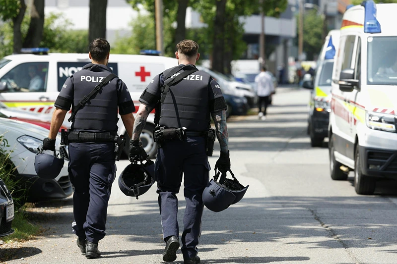 Two policemen walk past ambulance cars in a street close to a school where, according to reports, several people died in a shooting, on June 10, 2025 in Graz, southeastern Austria. Several people died in a school shooting, including the attacker, Austrian broadcaster ORF quoted the interior ministry as saying. (Photo by ERWIN SCHERIAU / APA / AFP) / Austria OUT (Photo by ERWIN SCHERIAU/APA/AFP via Getty Images)