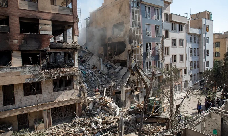 TEHRAN, IRAN - JUNE 13: An excavator removes debris from a residential building that was destroyed in today's attack by Israel in Tehran, on June 13, 2025 in Tehran, Iran. Early this morning, Iran was hit by a series of Israeli airstrikes targeting military and nuclear sites, as well as top military officials. (Photo by Majid Saeedi/Getty Images)