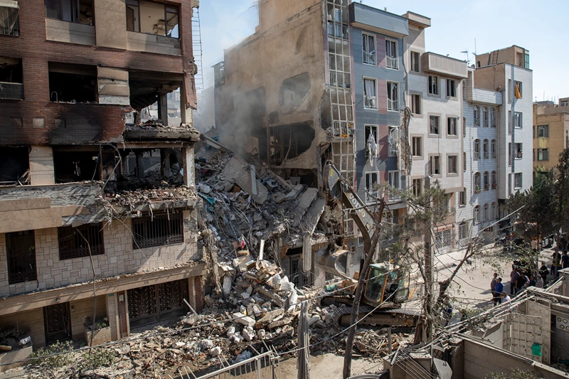 TEHRAN, IRAN - JUNE 13: An excavator removes debris from a residential building that was destroyed in today's attack by Israel in Tehran, on June 13, 2025 in Tehran, Iran. Early this morning, Iran was hit by a series of Israeli airstrikes targeting military and nuclear sites, as well as top military officials. (Photo by Majid Saeedi/Getty Images)