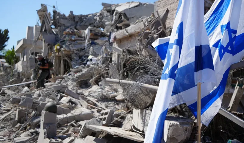 Israeli flags stand amid rubble and destruction in a residential area of Rishon LeZion, Israel on June 14, 2025. Extensive damage happened as a result of Iran's retaliatory strike involving around 100 missiles, launched after Israel attacked Iran on the night of June 1213, 2025. (Photo by Khadija Toufik / Middle East Images via AFP) (Photo by KHADIJA TOUFIK/Middle East Images/AFP via Getty Images)