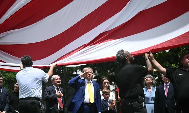 US President Donald Trump salutes as a US flag is raised on a newly installed flagpole on the South Lawn of the White House in Washington, DC on June 18, 2025. President Trump left the question of whether the United States will join Israeli strikes on Iran up in the air Wednesday, as he said that Tehran had reached out to seek negotiations. "I may do it, I may not do it. I mean, nobody knows what I'm going to do," Trump told reporters as he supervised the installation of a new flagpole on the White House South Lawn. (Photo by Brendan SMIALOWSKI / AFP) (Photo by BRENDAN SMIALOWSKI/AFP via Getty Images)