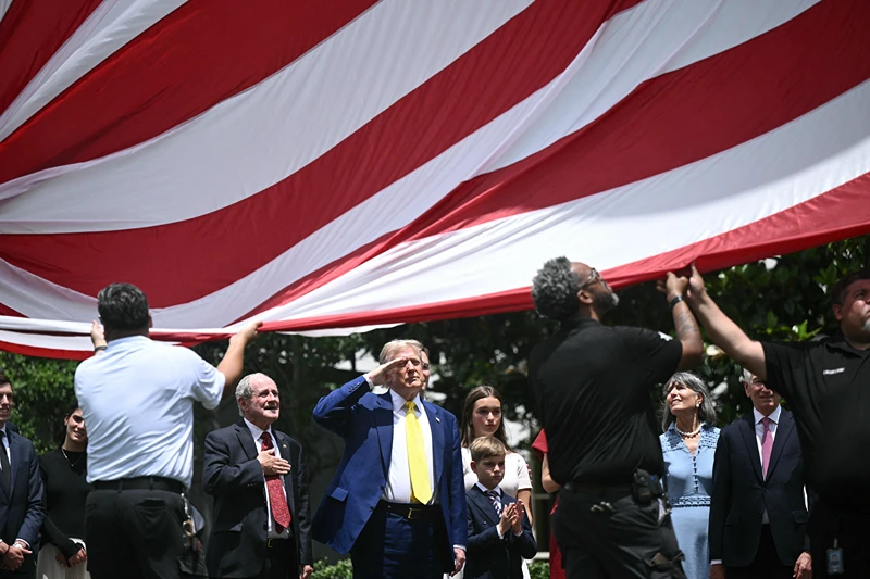 US President Donald Trump salutes as a US flag is raised on a newly installed flagpole on the South Lawn of the White House in Washington, DC on June 18, 2025. President Trump left the question of whether the United States will join Israeli strikes on Iran up in the air Wednesday, as he said that Tehran had reached out to seek negotiations. "I may do it, I may not do it. I mean, nobody knows what I'm going to do," Trump told reporters as he supervised the installation of a new flagpole on the White House South Lawn. (Photo by Brendan SMIALOWSKI / AFP) (Photo by BRENDAN SMIALOWSKI/AFP via Getty Images)
