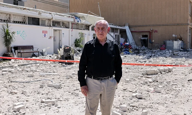 Israeli Prime Minister Benjamin Netanyahu stands amid debris outside the Soroka Hospital in the southern city of Beersheba, after it was hit by a missile fired from Iran on June 19, 2025. Israel's defence minister warned that Iran's supreme leader "can no longer be allowed to exist" after a hospital was hit in an Iranian missile strike on June 19, spiking tensions in the week-old war. (Photo by Marc Israel SELLEM / POOL / AFP) (Photo by MARC ISRAEL SELLEM/POOL/AFP via Getty Images)