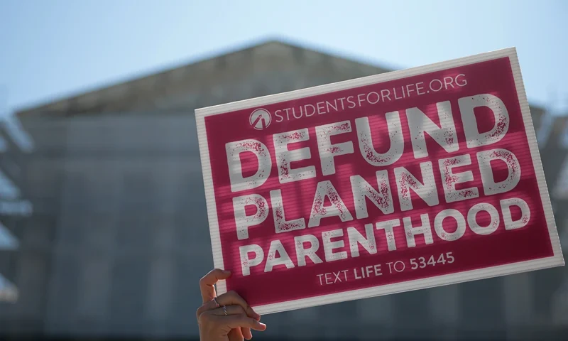 Protestors holding "Defund Planned Parenthood" signs stand outside of the U.S. Supreme Court on June 20, 2025 in Washington, DC. The Supreme Court began the morning with 16 cases to decide before the term ends and will end this week with 10 remaining. (Photo by Kayla Bartkowski/Getty Images)