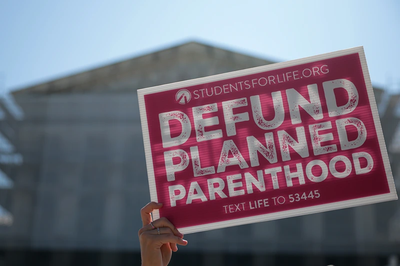 Protestors holding "Defund Planned Parenthood" signs stand outside of the U.S. Supreme Court on June 20, 2025 in Washington, DC. The Supreme Court began the morning with 16 cases to decide before the term ends and will end this week with 10 remaining. (Photo by Kayla Bartkowski/Getty Images)