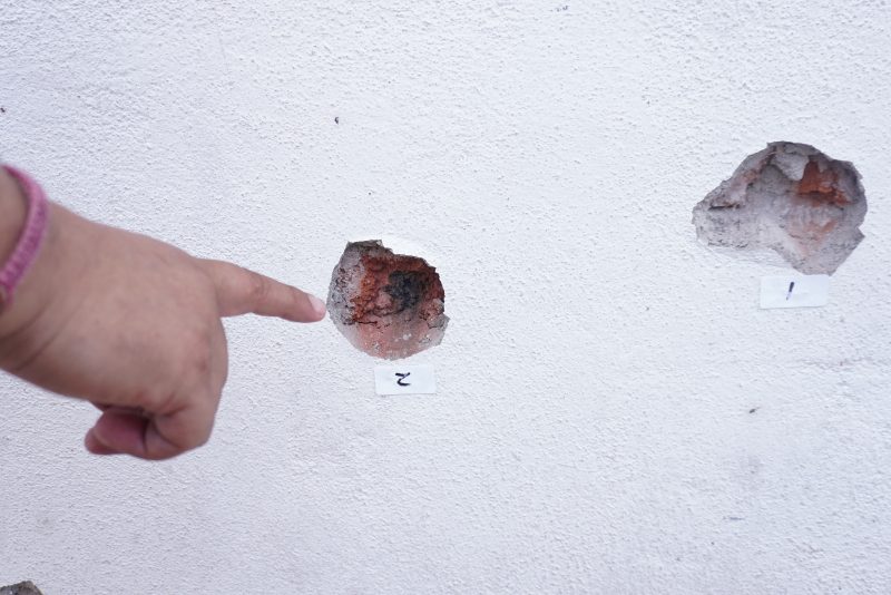 A person points at bullet holes on a wall after a shooting at the Barrio Nuevo neighbourhood in Irapuato, Guanajuato state, Mexico, on June 25, 2025. Gunmen killed 11 people and injured at least 20 in an attack during a religious festival in a central Mexican city plagued by gang-related violence, authorities said Wednesday. (Photo by MARIO ARMAS / AFP) (Photo by MARIO ARMAS/AFP via Getty Images)