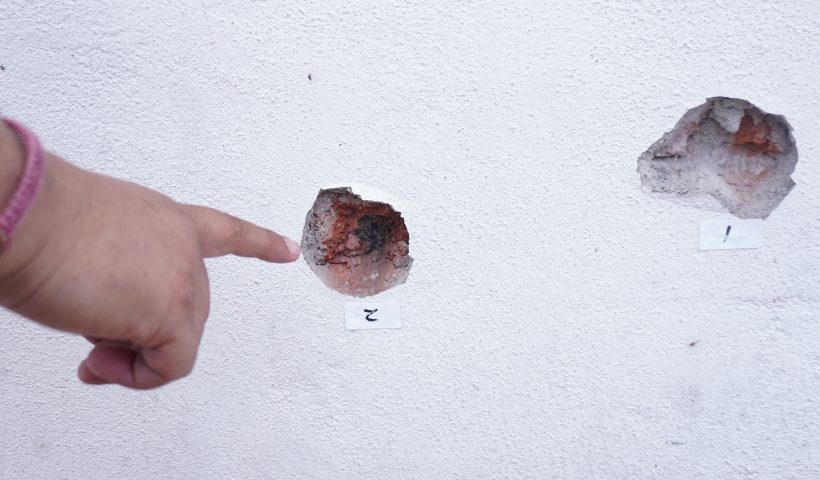 A person points at bullet holes on a wall after a shooting at the Barrio Nuevo neighbourhood in Irapuato, Guanajuato state, Mexico, on June 25, 2025. Gunmen killed 11 people and injured at least 20 in an attack during a religious festival in a central Mexican city plagued by gang-related violence, authorities said Wednesday. (Photo by MARIO ARMAS / AFP) (Photo by MARIO ARMAS/AFP via Getty Images)