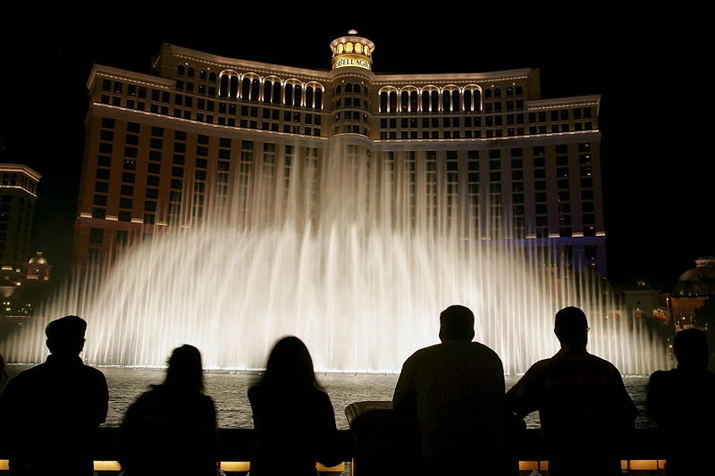 Tourists are silhouetted as they watch the Bellagio fountain show on the Las Vegas Strip October 12, 2005 in Las Vegas, Nevada. (Photo by Ethan Miller/Getty Images)