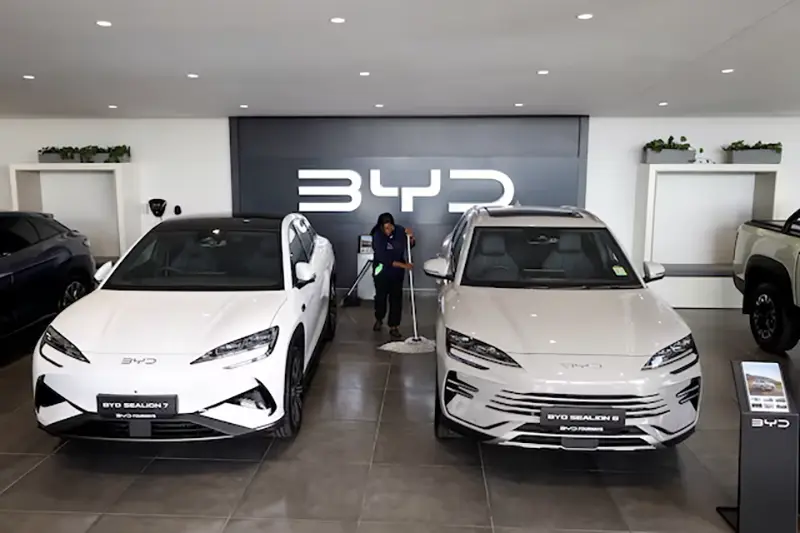 Amukelani Masungi, a worker, cleans the floor next to BYD vehicles on display at a BYD dealership in Sandton, South Africa, June 5, 2025. REUTERS/Siphiwe Sibeko/File Photo