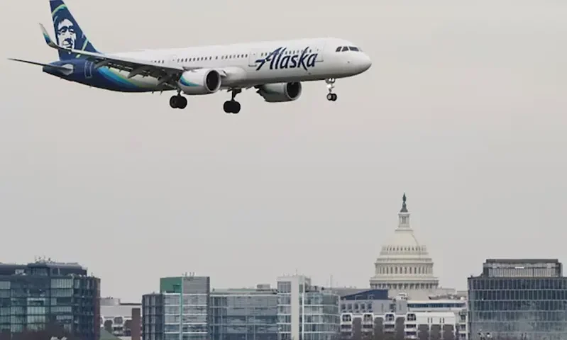 An Alaska Airlines aircraft flies past the U.S. Capitol before landing at Reagan National Airport in Arlington, Virginia, U.S., January 24, 2022. REUTERS/Joshua Roberts/File Photo