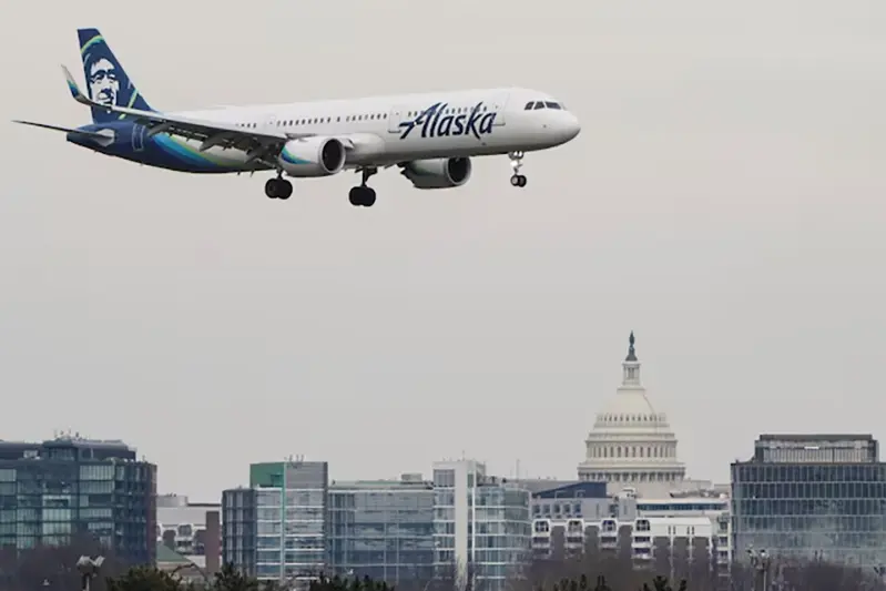 An Alaska Airlines aircraft flies past the U.S. Capitol before landing at Reagan National Airport in Arlington, Virginia, U.S., January 24, 2022. REUTERS/Joshua Roberts/File Photo