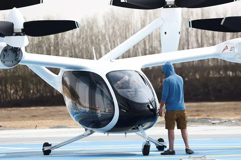 A technician gestures to a pilot flying an experimental Joby Dubai Aerial Taxi aircraft in Dubai, United Arab Emirates, June 30, 2025. REUTERS/Amr Alfiky